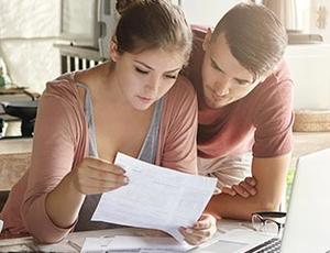A couple reviews utility bills at home